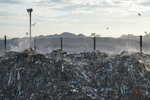 a-pile-of-garbage-sitting-next-to-a-street-light