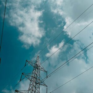 A transmission tower against a blue sky with clouds.